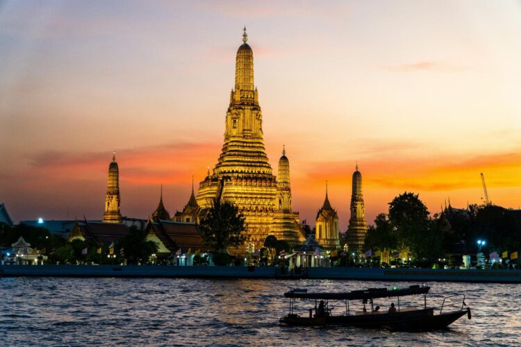Two boats floating on the water in front of a tall building